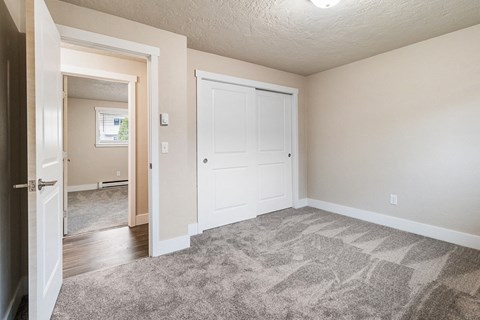 an empty living room with a door to a bedroom